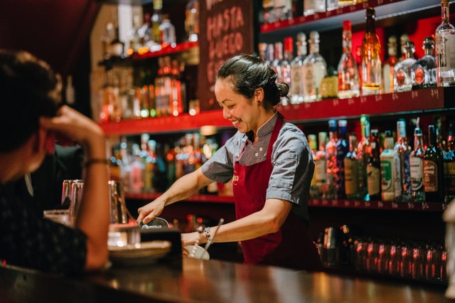 happy bartender smiles while doing her job