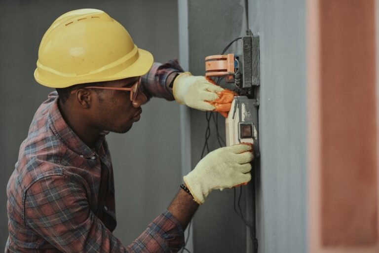 Trainee electrician in a yellow hard hat wiring a wall panel, one of the trade paths behind certifications that pay well within a year