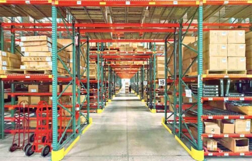 Costco interview questions prep: tall warehouse racking stacked with boxed inventory along a wide aisle