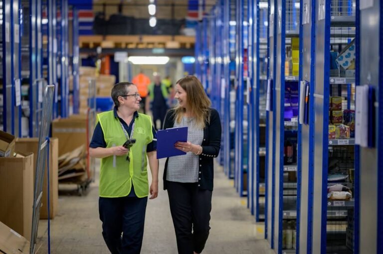Two warehouse employees walking a storage aisle, one of the jobs that hire felons most often