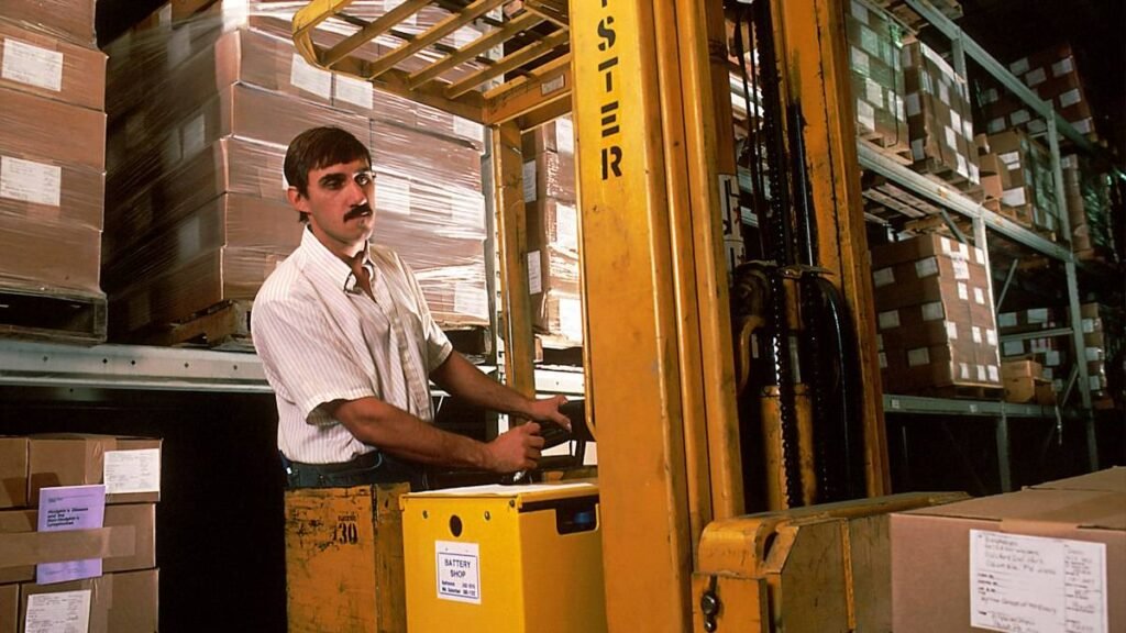 Jobs that don't drug test vs. roles that do: a warehouse worker driving a forklift between pallet racks