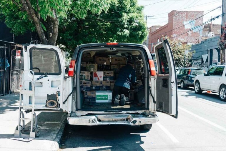 Delivery worker loading cartons into a van, the kind of work behind seasonal jobs at FedEx