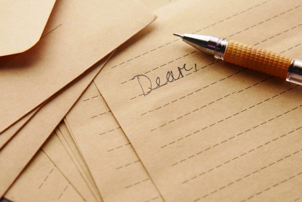 two weeks notice letter started with the word Dear and a pen on kraft paper