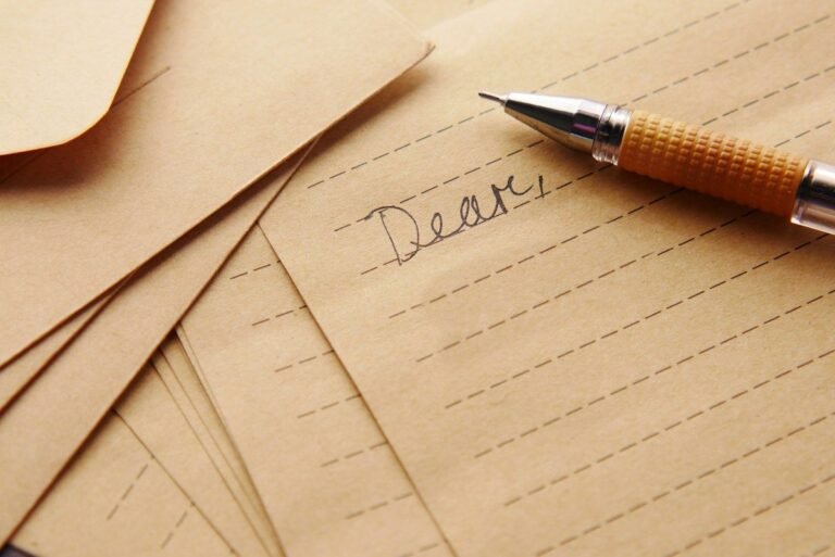 two weeks notice letter started with the word Dear and a pen on kraft paper