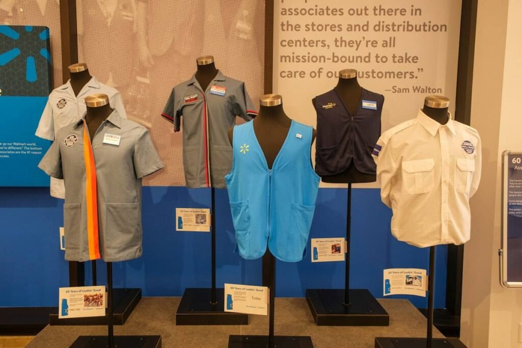 Walmart 401k guide for associates: decades of Walmart associate uniforms and vests displayed on mannequins